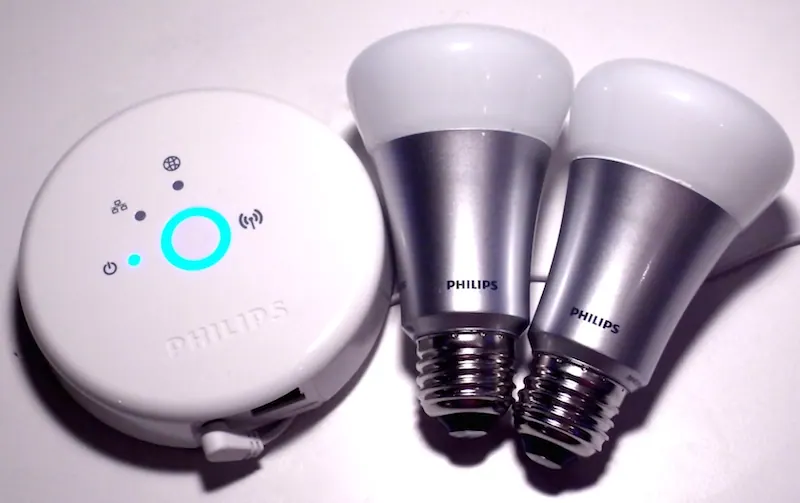 هاب Zigbee گرد فیلیپس Hue در کنار دو لامپ هوشمند با سرپیچ E27